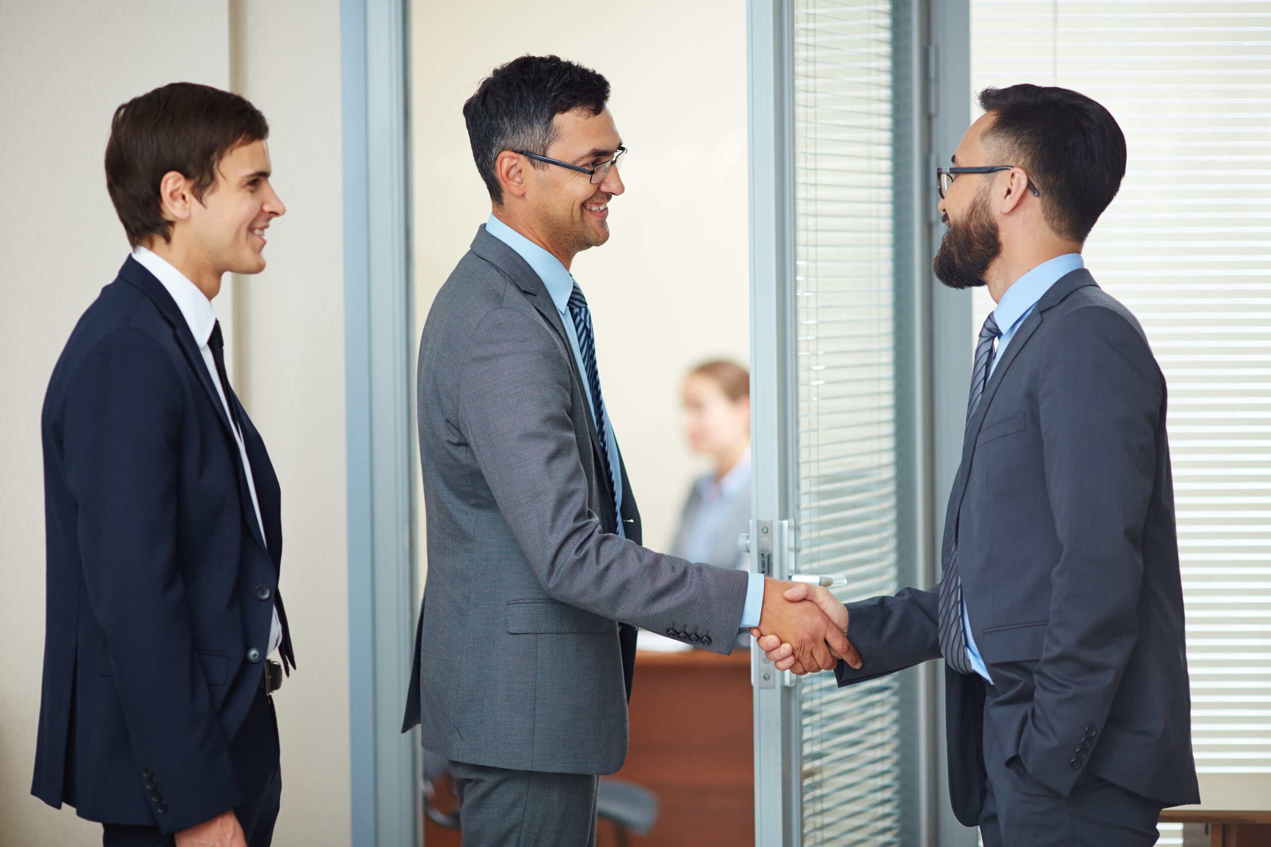 businessmen closing deal with handshake scaled
