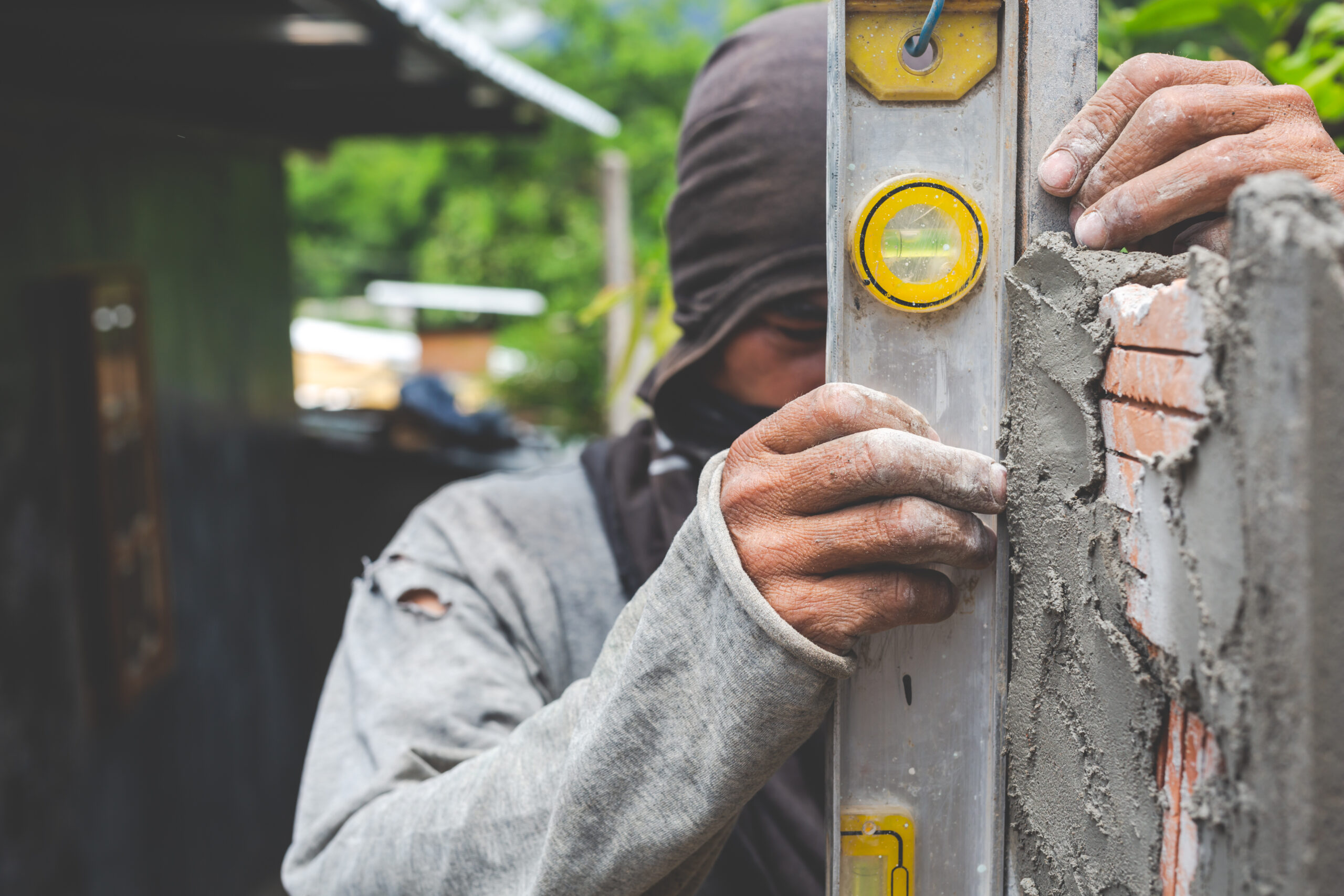 bricklaying construction worker building brick wall scaled