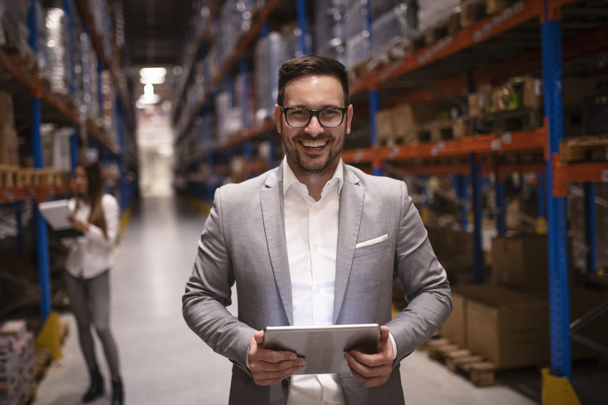 cheerful successful middle aged manager businessman holding tablet computer large warehouse organizing distribution scaled