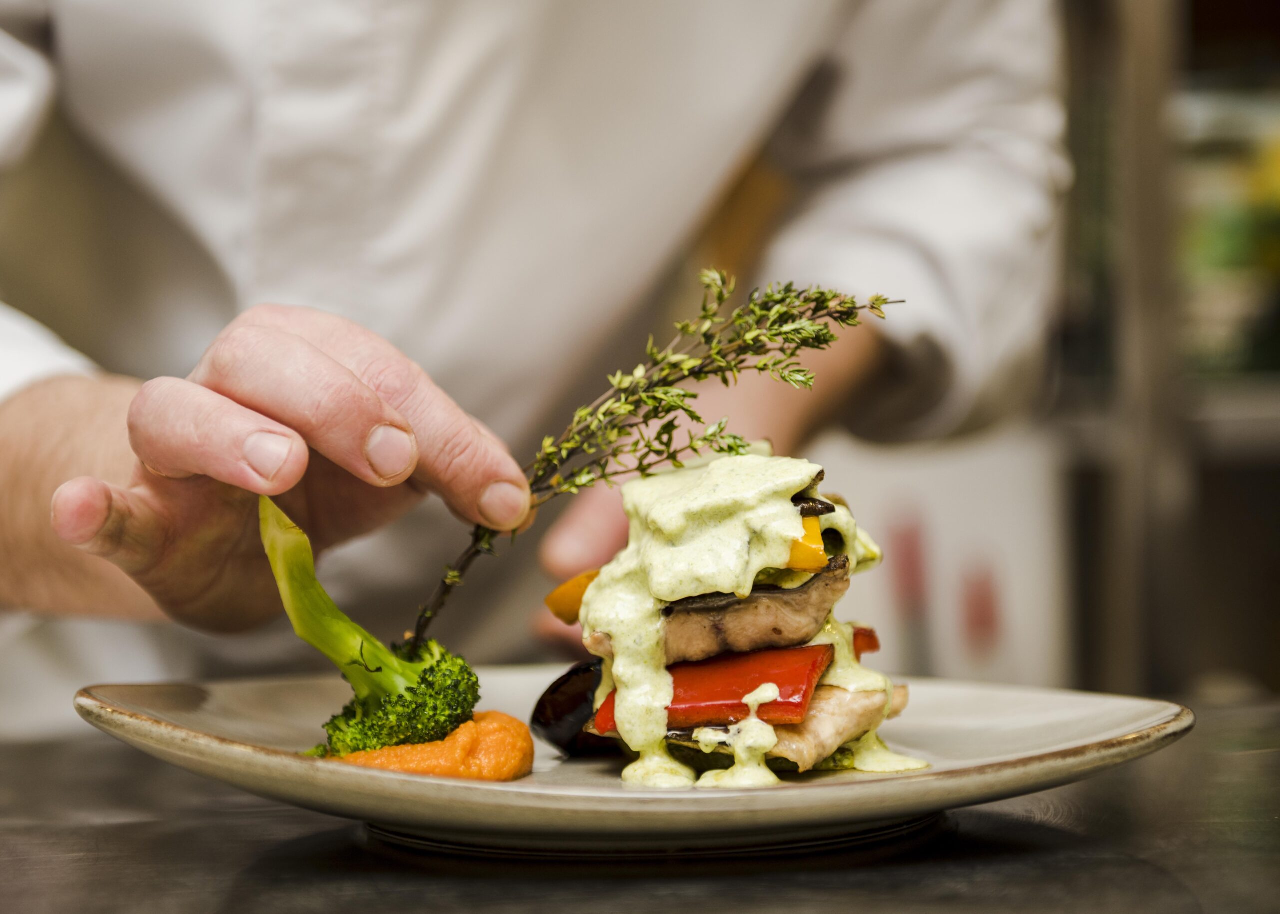 chef placing herb gourmet meal scaled