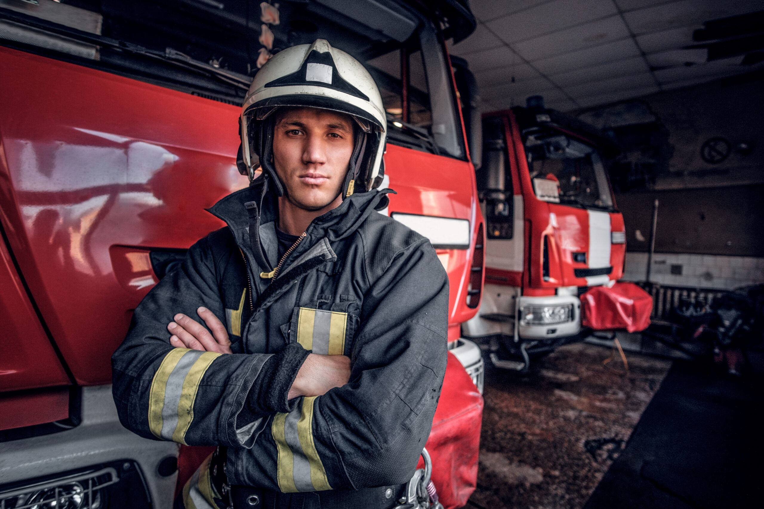 confident fireman wearing protective uniform standing fire engine garage fire department crossed arms looking camera scaled