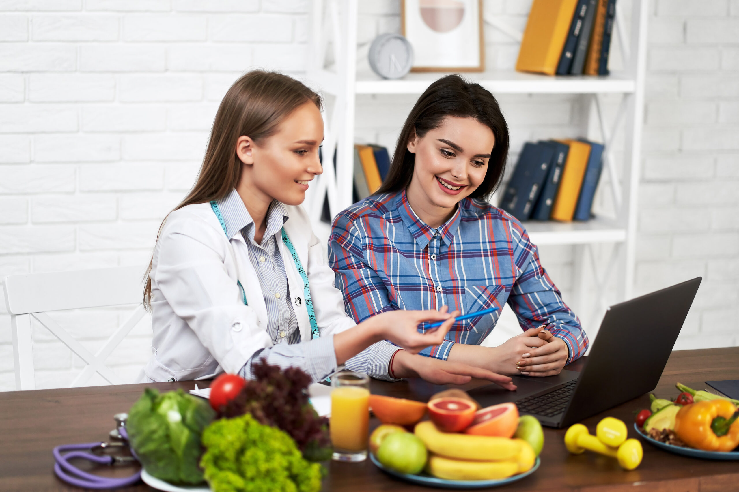 smiling nutritionist advises young patient woman proper nutrition dieting scaled